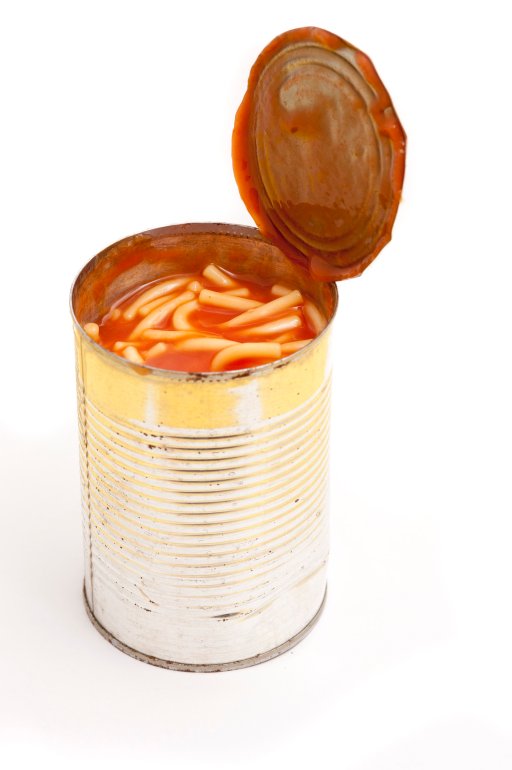Opened unlabelled tin of canned spaghetti in tomato sauce on a white background, high angle view