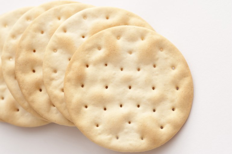 Close-up of several crusty crackers lying on white background