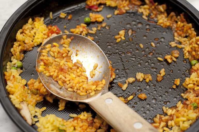 remains of paella or risotto on a metal spoon