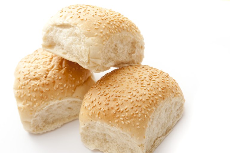 Close Up Still Life of Three White Sesame Bun Bread Rolls Stacked on White Studio Background with Copy Space