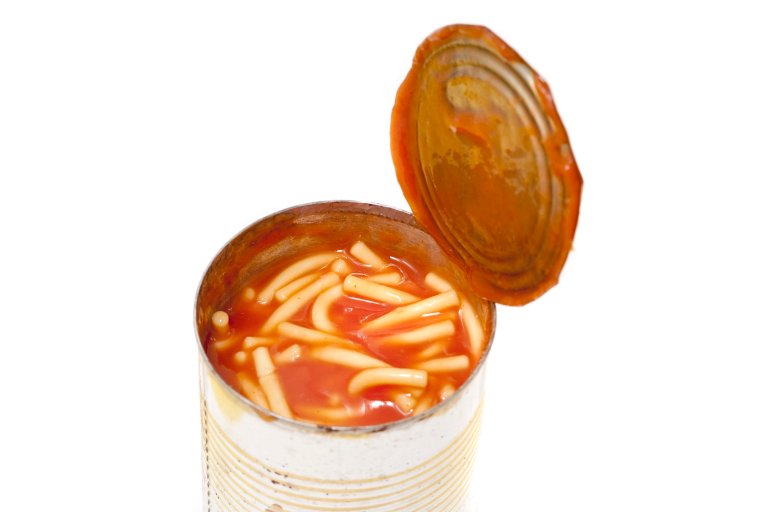 Opened tin of canned spaghetti in tomato sauce, a favourite snack with children and quick nutritious meal, isolated on white