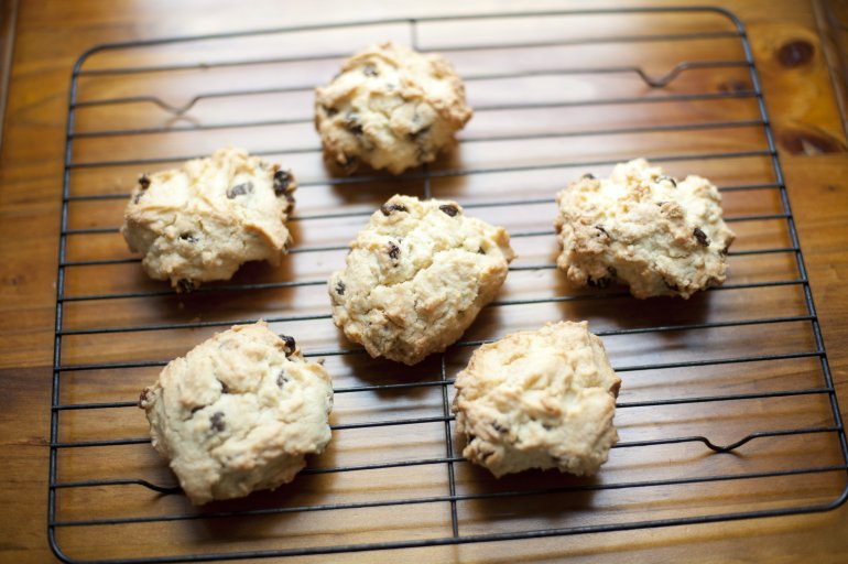 Scrumptious set of six rock scones filled with date pieces on cooling rack over wooden table
