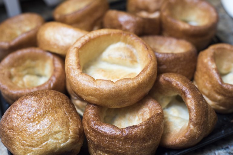 Close up view of small round yorkshire pudding morsels browned around its edges with a creamy middle