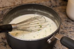 Pot of bechamel sauce with a whisk