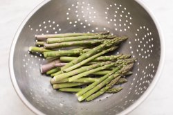 Cut asparagus spears in colander