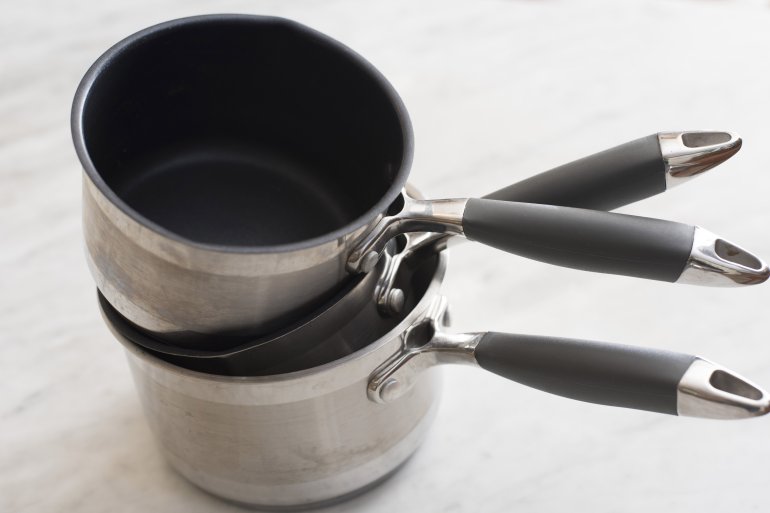 Three clean empty stainless steel pots with non-stick interiors stacked on top of each other