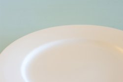 Partial view of an empty clean white dinner plate