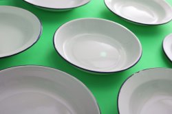 Clean white enamelled plates on green
