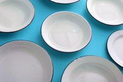 Set of scattered white enamel metal dinner plates