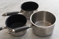 Three empty clean metal saucepans