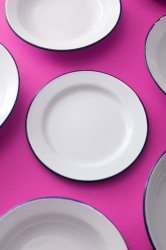 Clean white enamel plates on a purple background