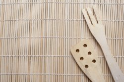 Plain wooden fork and spatula on a bamboo mat
