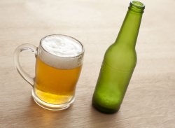 Beer in a glass beer mug with empty bottle