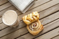 Pastries with cafe latte and a newspaper