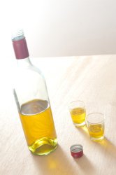 Bottle and Glasses of Yellow Wine on Table