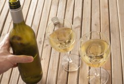 Man pouring white wine into two glasses