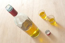 Bottle of alcoholic drink near two shot glasses