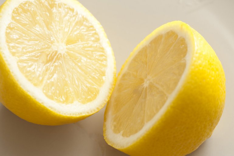 A lemon sliced in two on a grey background