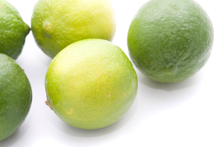 Fresh whole limes, an acidic citrus fruit with a tangy taste used as a flavouring in cooking and as a garnish