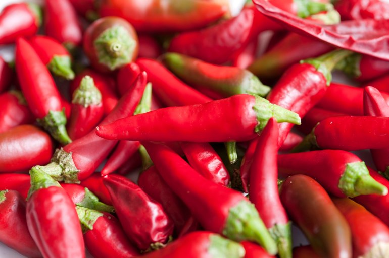 Background of fresh red hot chili peppers, or cayenne chillis, a pungent strong flavoured spice used in cooking