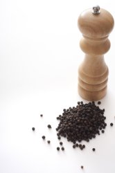 Wooden pepper mill with dried black peppercorns