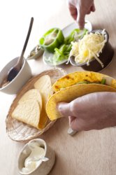 Man filling a taco with fresh ingredients