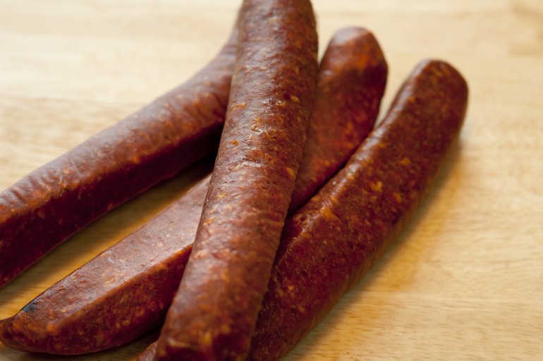 Close-up of four sausages on board