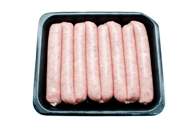 Uncooked linked pork sausages neatly arranged in a disposable plastic tray on a white background