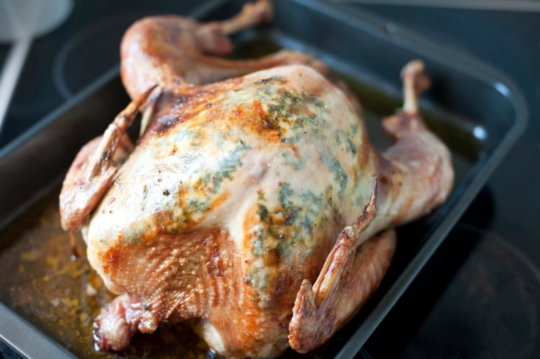 Thanksgiving or Christmas roast turkey in an oven pan during preparation of a festive nutritious meal