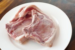 uncooked pork chops on plate