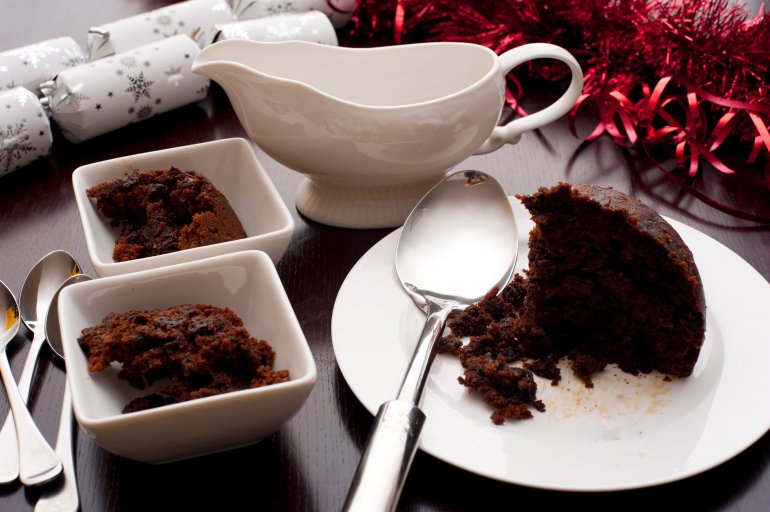 Servings of delicious rich spiced fruity Christmas pudding in bowls on a seasonal festive Xmas table