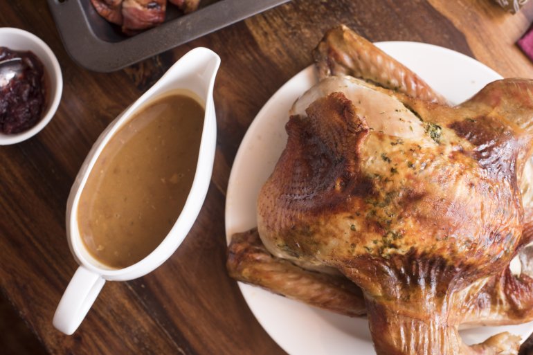 Roast Christmas or Thanksgiving turkey and gravy served on a table ready to be carved for a festive holiday celebration