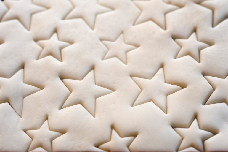 Decorative Christmas icing on top of a cake with a pattern or impressed stars, background close up view