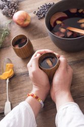 Person cradling a mug of warm mulled wine