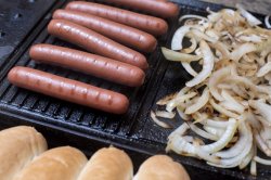 Preparing a tasty hot dogs on a grill