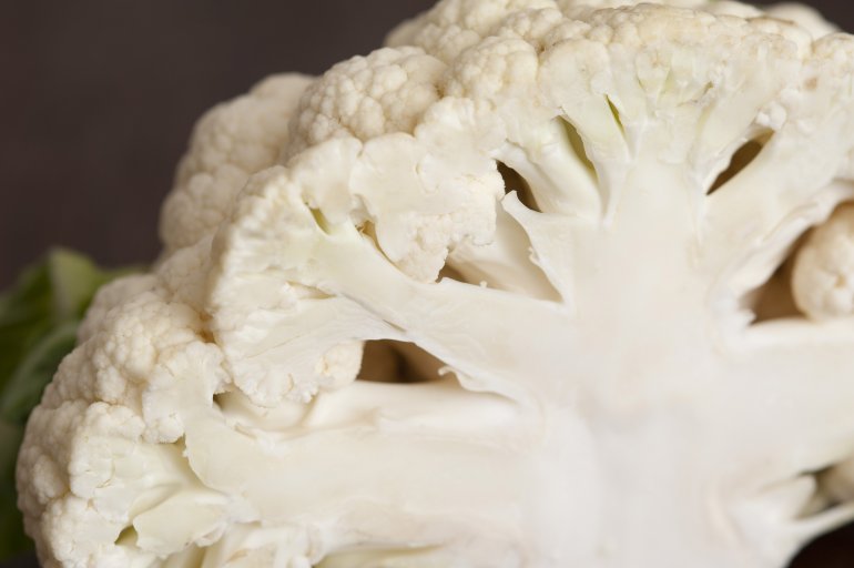 Cut in half white cauliflower in macro close-up against black background