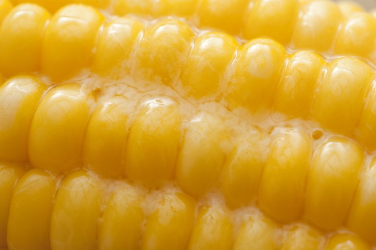 Macro full frame close up view of melted butter on hot sweet corn kernels