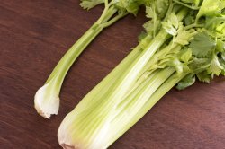 Bunch of fresh green celery on a chopping board