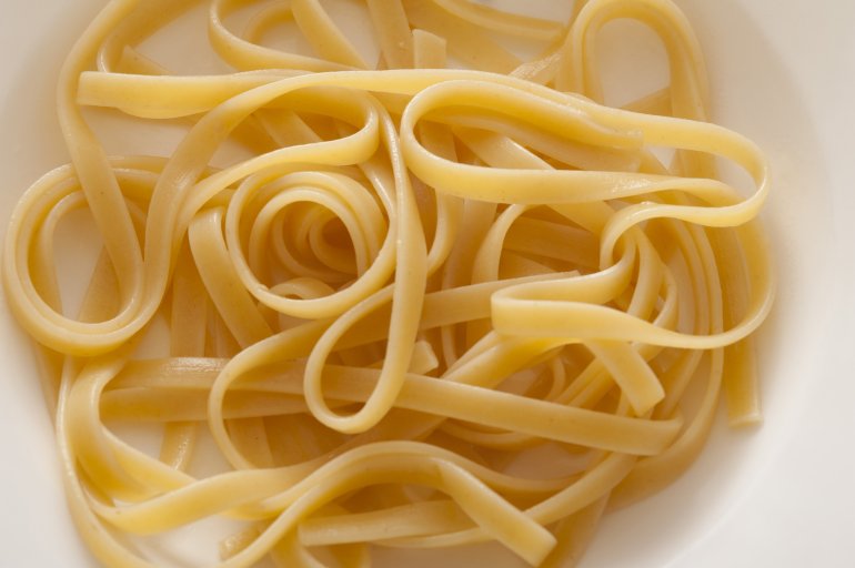High Angle Close Up of Cooked Plain Linguine or Fettucine Noodles in White Bowl and Ready for Sauce