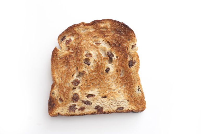 One roasted crusty slice of bread with raisin.Isolated