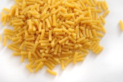 Pile of Dry Uncooked Macaroni on White Background