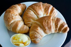 Three flaky golden croissants
