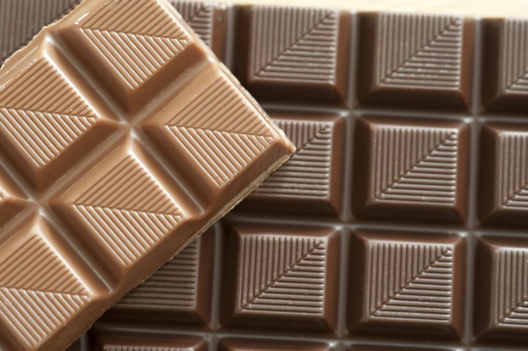 Top down cropped view on deliciously sweet milk and dark chocolate squares with little diagonal lines etched into them