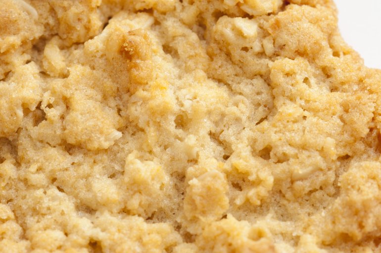 Close up texture of a freshly baked homemade golden oatmeal cookie in a cooking and food background