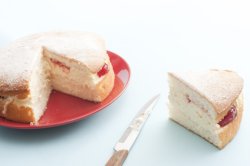 wedge of sponge cake with jam and cream