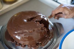 Hand cutting gooey chocolate cake