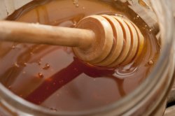 Dipping honey with a wooden dip stick