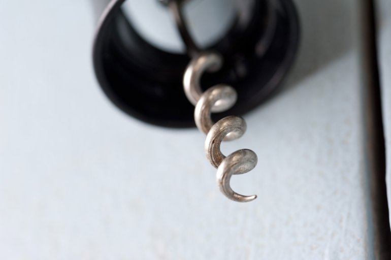 Sharp spiral point on a steel bottle opener or corkscrew in a close up macro view with copy space