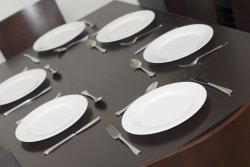 Black dining table set with clean white plates