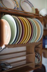 Colorful ceramic plates in a wooden plate rack